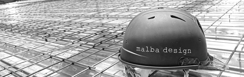 鉄筋が組まれた現場に置かれた、malba designのロゴ入りヘルメット