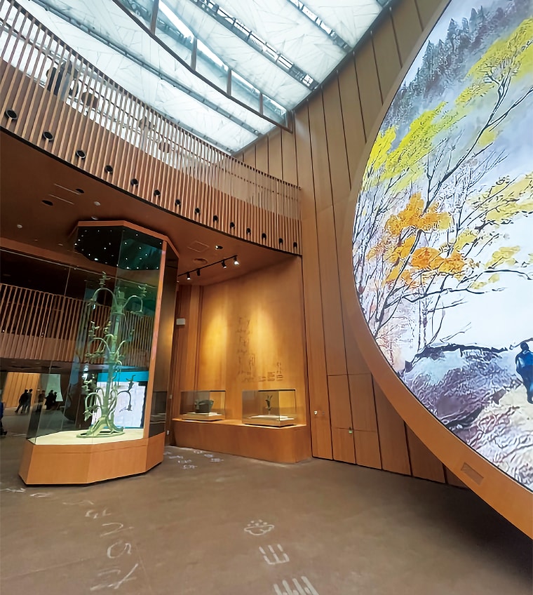 竹を配した展示ケースと、紅葉が描かれた円形の大型ビジュアル